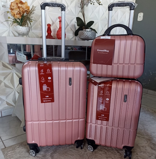"Mala de viagem média GrandBag preta, fabricada em ABS reforçado com acabamento texturizado anti-risco, equipada com zíper expansor, rodinhas duplas 360 graus estilo avião, alça superior e lateral, e divisória interna com zíper. Dimensões: 67 cm de altura, 45 cm de largura e 27 cm de profundidade."