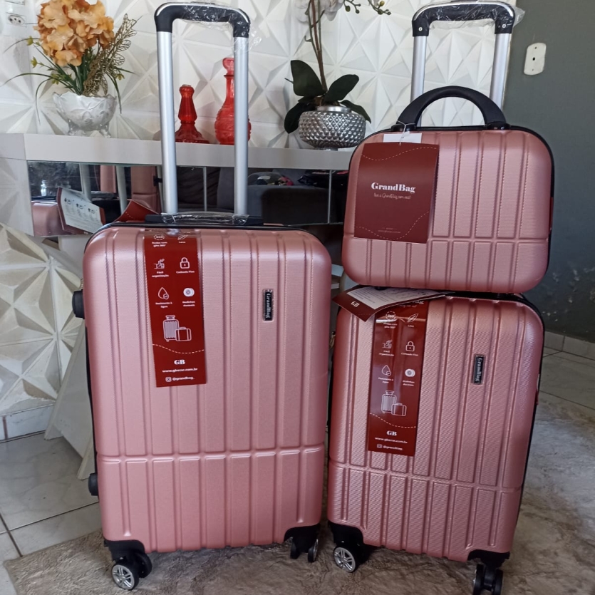 "Mala de viagem média GrandBag preta, fabricada em ABS reforçado com acabamento texturizado anti-risco, equipada com zíper expansor, rodinhas duplas 360 graus estilo avião, alça superior e lateral, e divisória interna com zíper. Dimensões: 67 cm de altura, 45 cm de largura e 27 cm de profundidade."